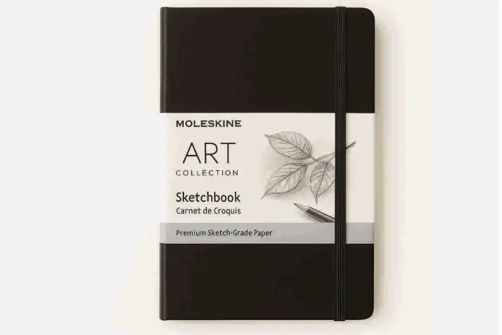 Moleskine Art Collection Sketchbook with black hardcover and elastic band, featuring a white label with pencil leaf sketch and text, displayed on white background