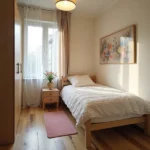 dormitorio pequeño moderno con cama y cubecama color blanco-al lado de una ventana iluminada